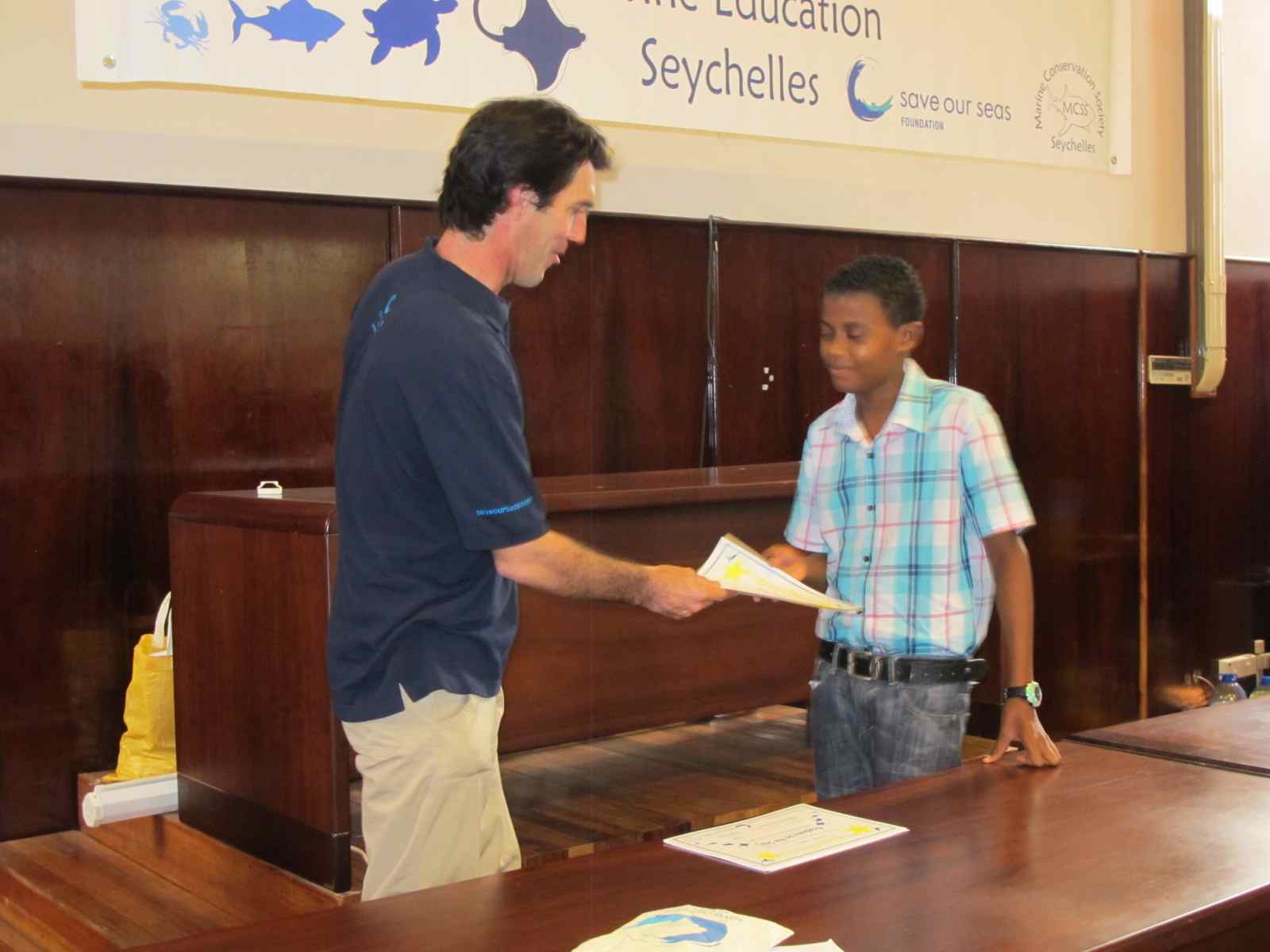 Save Our Seas Educator Paul Millar from South Africa hands out a bursary certificate